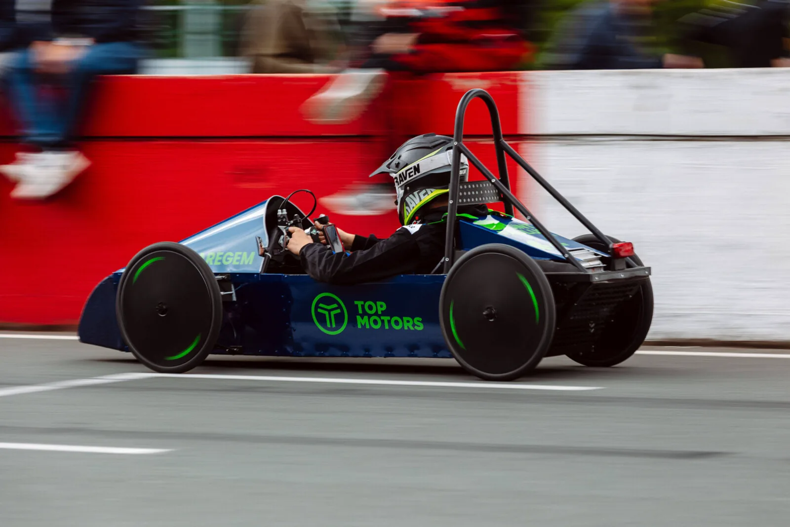 Greenpower race car at speed along the barriers