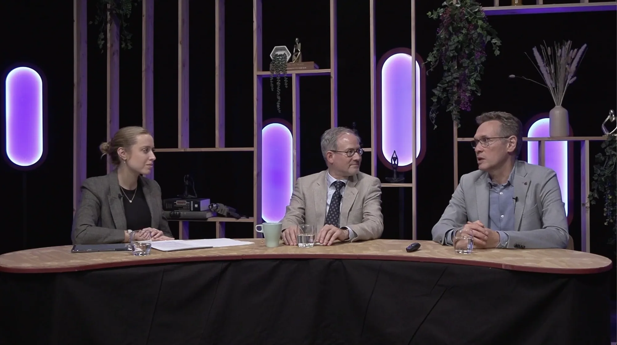 Trois intervenants en conversation sur le plateau du studio
